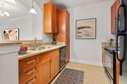 Fayetteville apartment for rent - a kitchen with wooden cabinets and a sink and a refrigerator at The Villagio Apartments, North Carolina, 28303