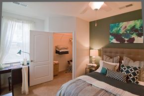 Woodbridge apartment for rent - A bedroom with a large bed and a painting on the wall. at Kensington Place Apartments, Woodbridge, VA