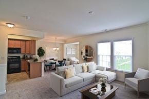 Manassas apartment for rent - A well-lit, spacious living room with a kitchen area in the background. at Barrington Park Apartments, Manassas, Virginia
