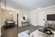 Washington apartment for rent - A living room with a white couch, a coffee table, and a mirror on the wall. at Columbia Uptown Apartments, Washington DC, 20009