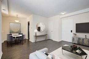 Washington apartment for rent - A living room with a white couch, a coffee table, and a mirror on the wall. at Columbia Uptown Apartments, Washington DC, 20009