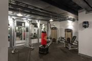 Washington apartment for rent - A gym with a variety of equipment including a squat rack, a bench, and a barbell. at Columbia Uptown Apartments, Washington DC, 20009