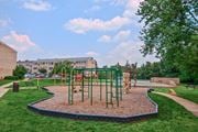 Herndon apartment for rent - A playground with a red swing set and a green slide at Dulles Glen Apartments, Herndon