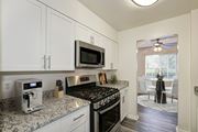 Fairfax apartment for rent - A kitchen with a black stove top oven and a microwave above it at Fairfax Square Apartments, Fairfax, Virginia