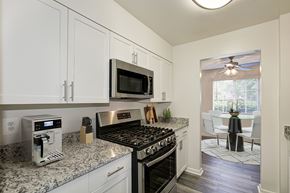 Fairfax apartment for rent - A kitchen with a black stove top oven and a microwave above it at Fairfax Square Apartments, Fairfax, Virginia