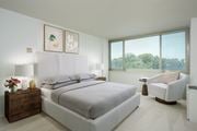 Alexandria apartment for rent - A bedroom with a large bed, a chair, and a window overlooking trees.