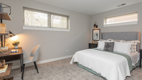 Chicago apartment for rent - a bedroom with a bed and a desk and two windows
