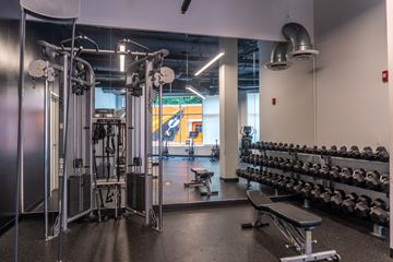 Evanston apartment for rent - A gym with a variety of equipment including weights and a leg press machine.