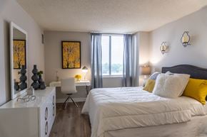 Arlington Heights apartment for rent - Bedroom with gray upholstered bed and yellow accents at Dunton Tower Apartments, Illinois