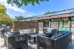 Naperville apartment for rent - A patio with a table and chairs and a pool in the background.