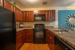 Mount Prospect apartment for rent - Kitchen with cherry cabinets and black appliances at Forest Cove Apartments, Illinois