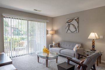 Arlington Heights townhouse for rent - A living room with a grey couch, a glass table, and a painting on the wall.