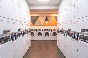 Shared laundry room with modern washers and dryers