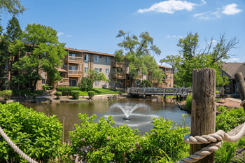 Apartment buildings surrounding serene pond with fountain