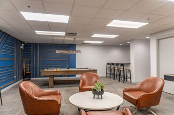 Community club room with fireplace, billiards table, and kitchen
