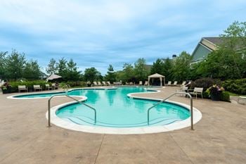 Resort-style outdoor swimming pool with cabanas and hammock park