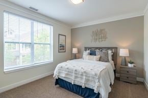 St. Charles apartment for rent - A bedroom with a large bed and a window with blinds.