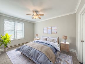 Chicago apartment for rent - A bedroom with a bed, two lamps, and a ceiling fan.