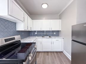 Chicago apartment for rent - A kitchen with white cabinets and a black stove top oven.