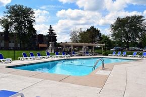 Glen Ellyn apartment for rent - A swimming pool surrounded by chairs and trees.