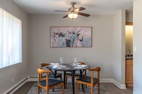 Glen Ellyn apartment for rent - A dining room with a table set for two and a painting on the wall.