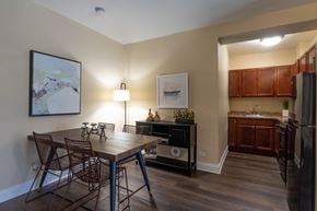 Chicago apartment for rent - A kitchen with a table and chairs in the foreground and a fridge in the background.