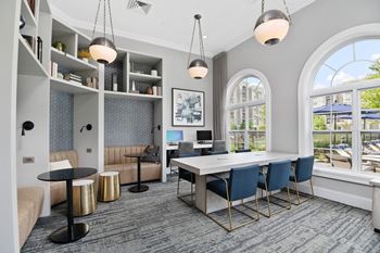Resident workspace with conference table and modern pendant lights