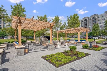 Courtyard with wooden pergolas and paver stone seating