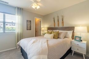 Bloomingdale apartment for rent - A bedroom with a large bed, a ceiling fan, and a window with blinds.
