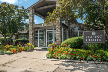 Bloomingdale apartment for rent - A leasing center is surrounded by flowers and trees.