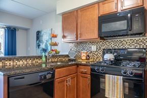 Schaumburg apartment for rent - A kitchen with a black microwave above a stove.