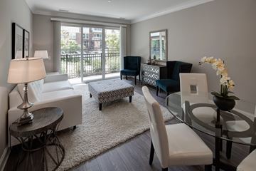 Deerfield apartment for rent - A well-lit, modern living room with a glass table and white chairs.