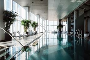 Philadelphia apartment for rent - A large indoor swimming pool with lounge chairs and plants.