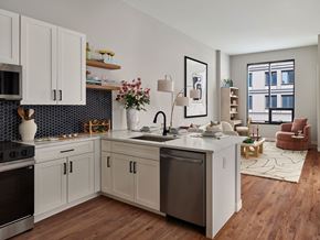 Philadelphia apartment for rent - A modern kitchen with wooden floors and white cabinets.