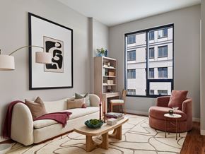 Philadelphia apartment for rent - A living room with a white couch, a wooden coffee table, and a red armchair.
