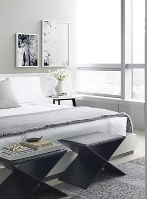 Philadelphia apartment for rent - A modern bedroom with a large bed and a small table with a vase of flowers on it.