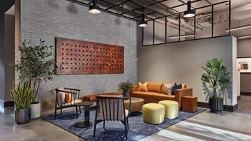 Philadelphia apartment for rent - A modern living room with a wooden panelled wall and a sofa set.