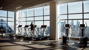 Philadelphia apartment for rent - A person is exercising on a treadmill in a brightly lit gym with a view of the city.