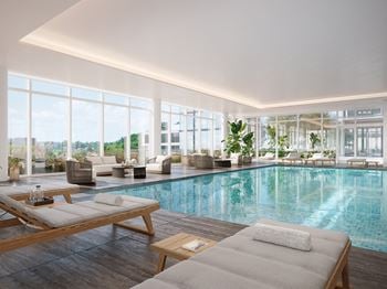 A swimming pool in a building with floor to ceiling windows 