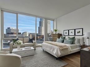 White Plains apartment for rent - A bedroom with a large bed and a view of the city.