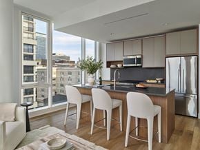 White Plains apartment for rent - A modern kitchen with white chairs and a view of the city.