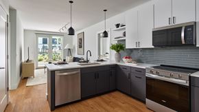 Philadelphia apartment for rent - A modern kitchen with dark grey cabinets and stainless steel appliances.
