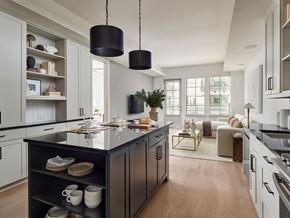 Phoenix apartment for rent - A modern kitchen with a black island and pendant lights.