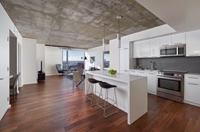 West Hollywood apartment for rent - A modern kitchen with a wooden floor and white cabinets.