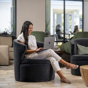 A woman sitting in a chair with a laptop