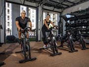 Phoenix apartment for rent - two men working out on exercise bikes in a gym at AVE Phoenix Terra, Phoenix, Arizona