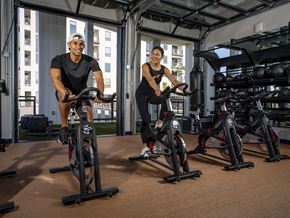 Phoenix apartment for rent - two men working out on exercise bikes in a gym at AVE Phoenix Terra, Phoenix, Arizona