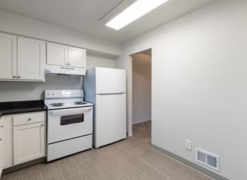 Grand Blanc townhouse for rent - a kitchen with white appliances and white cabinets and a white refrigerator