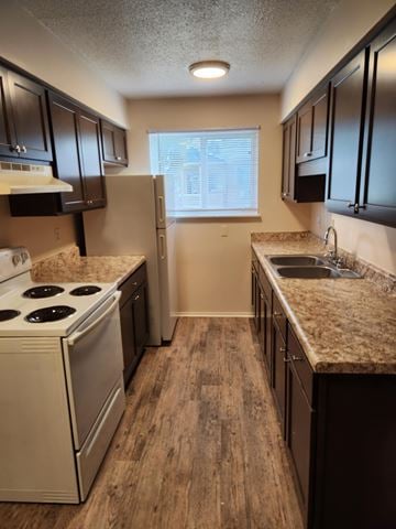 Flint apartment for rent - A kitchen with a white stove and dark brown cabinets.