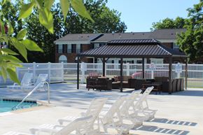 Swartz Creek townhouse for rent - a pool with chairs and a gazebo in front of a house